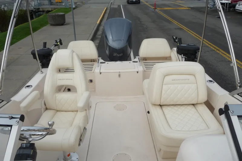 Slide: The Image of 2021 Grady-White Freedom 215 boat interior with cream seating and steering wheel. - 16
