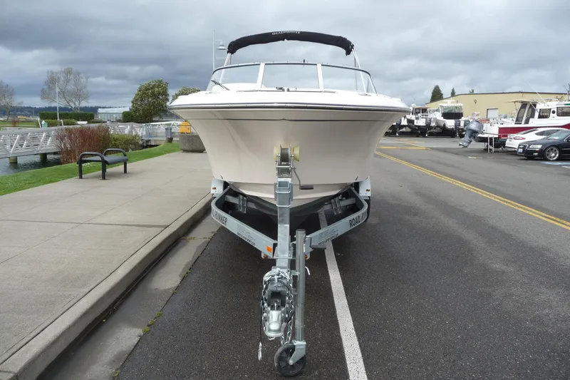 Slide: The Image of 2021 Grady-White Freedom 215 boat on trailer, parked near waterfront under cloudy skies. - 8