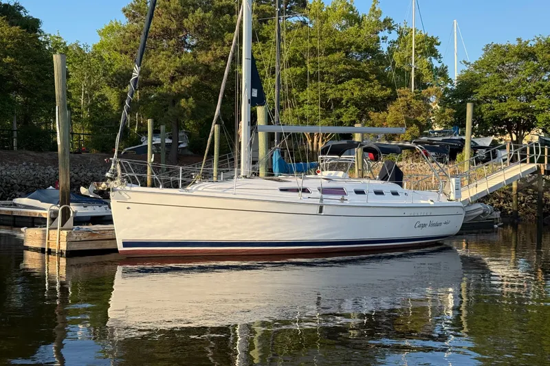 Slide: The Image of 2009 Hunter 38 sailboat docked in a serene marina setting. - 7