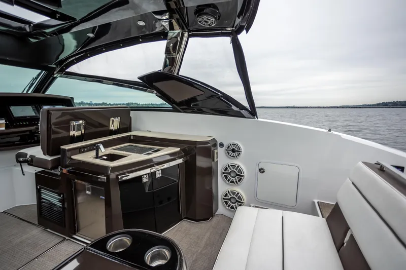 Slide: The Image of Interior of a 2019 Cobalt A36 boat featuring a sleek kitchenette and seating area. - 16