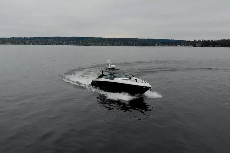 Slide: The Image of 2019 Cobalt A36 boat cruising on a calm lake under overcast skies. - 4