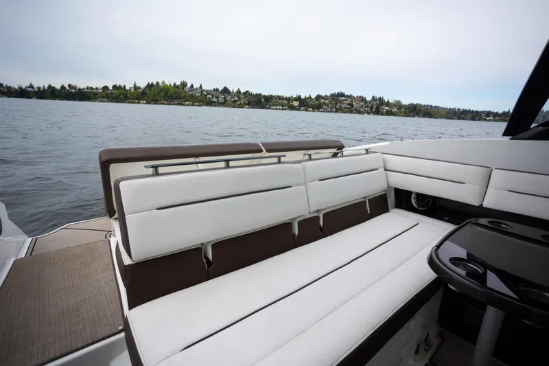 Slide: The Image of 2019 Cobalt A36 boat interior with white seating, overlooking a scenic lake view. - 8