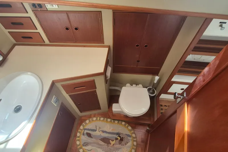 Slide: The Image of 1983 Grand Banks 42 Motoryacht bathroom with wooden cabinetry and marine toilet. - 18