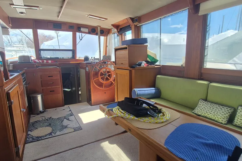 Slide: The Image of Interior of 1983 Grand Banks 42 Motoryacht with wooden helm and green seating. - 2