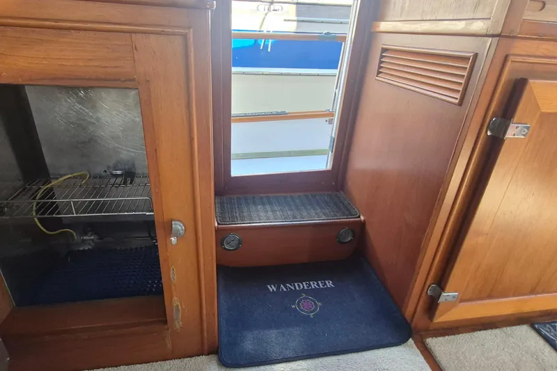 Slide: The Image of Interior of 1983 Grand Banks 42 Motoryacht with wooden helm and open fridge. - 28