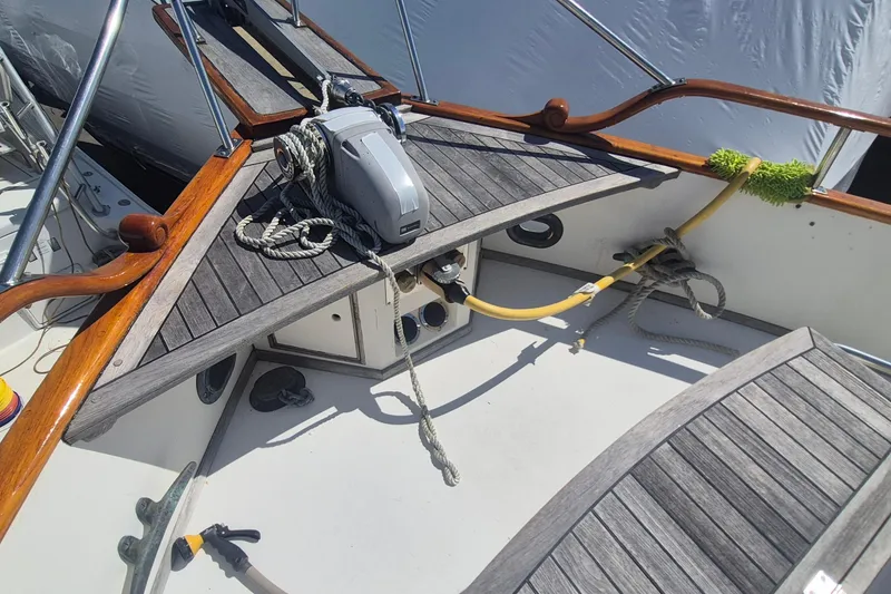 Slide: The Image of 1983 Grand Banks 42 Motoryacht deck with wooden railings and anchor equipment. - 34