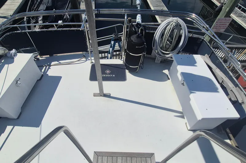 Slide: The Image of 1983 Grand Banks 42 Motoryacht deck with storage, ropes, and fenders in marina setting. - 39