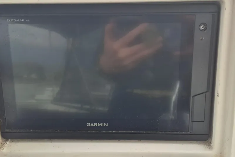 Slide: The Image of 1983 Grand Banks 42 Motoryacht helm with wooden steering wheel and covered seats. - 47