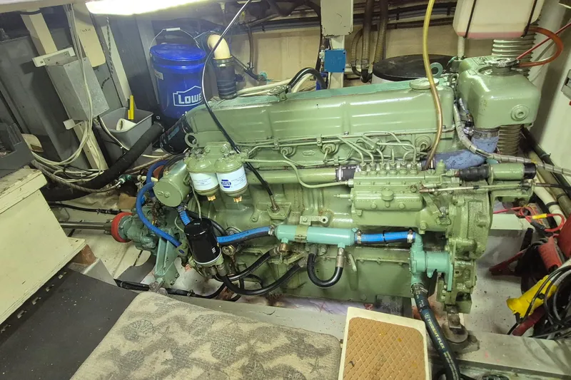 Slide: The Image of Engine room of a 1983 Grand Banks 42 Motoryacht with visible machinery and tools. - 56