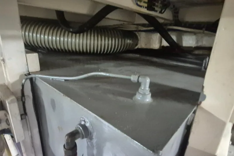 Slide: The Image of Engine compartment of a 1983 Grand Banks 42 Motoryacht, showcasing mechanical components and hoses. - 61