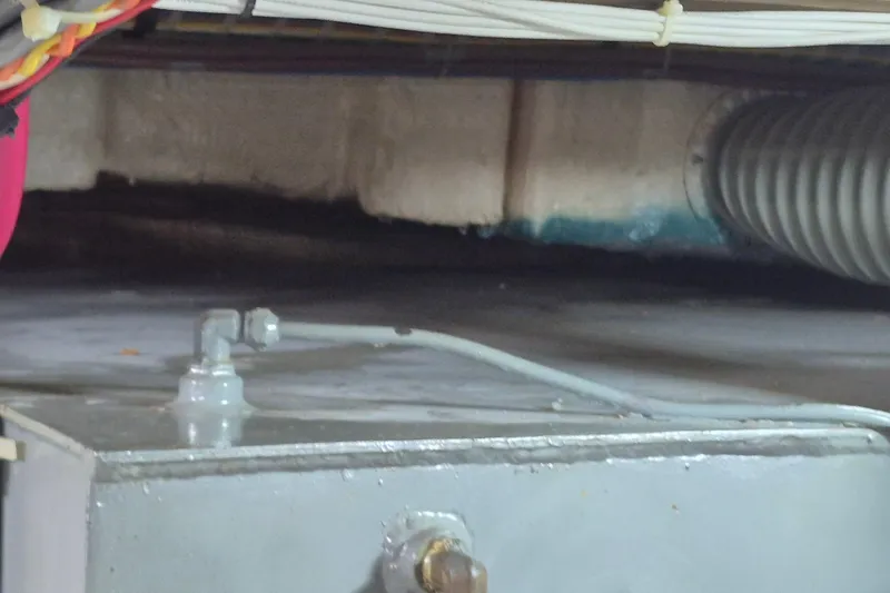 Slide: The Image of Engine compartment of a 1983 Grand Banks 42 Motoryacht, showing pipes and fittings. - 62