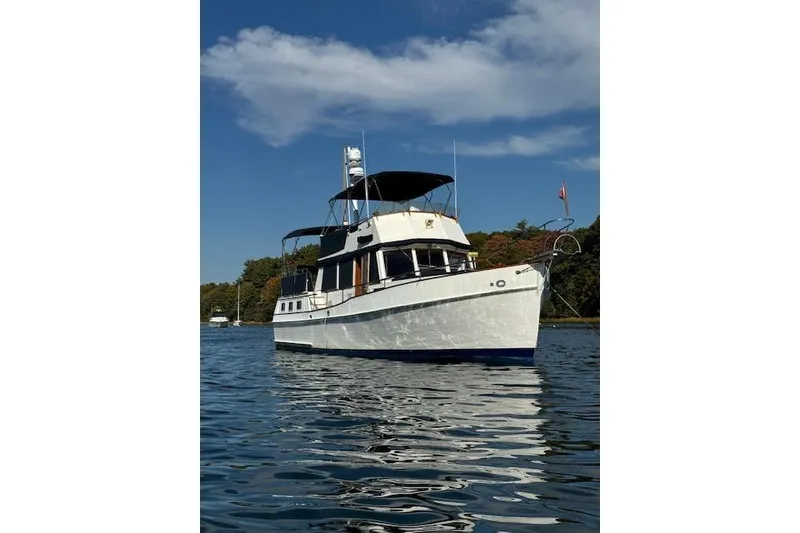 Slide: The Image of 1983 Grand Banks 42 Motoryacht on calm water under a clear blue sky. - 64