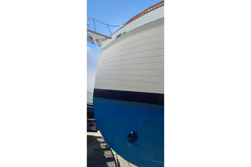 Slide: The Image of 1983 Grand Banks 42 Motoryacht hull with blue and white paint, docked under clear sky. - 65