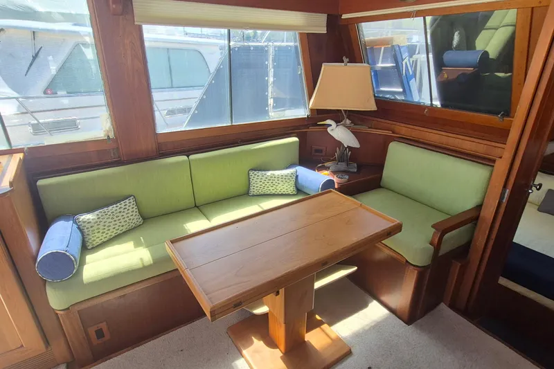 Slide: The Image of Interior of 1983 Grand Banks 42 Motoryacht with green seating and wooden table. - 8