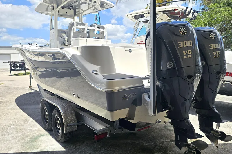 Slide: The Image of 2022 NauticStar 28 XS boat on trailer, parked outdoors under a sunny sky. - 2