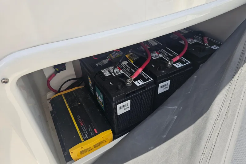 Slide: The Image of 2022 NauticStar 28 XS boat interior with seating and helm, parked outdoors. - 38