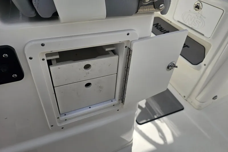 Slide: The Image of 2022 NauticStar 28 XS boat interior with seating and storage, displayed at a marina. - 44