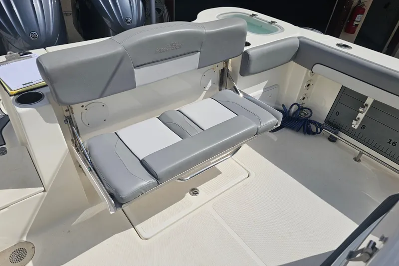 Slide: The Image of 2022 NauticStar 28 XS boat interior with gray seating and fishing equipment. - 48