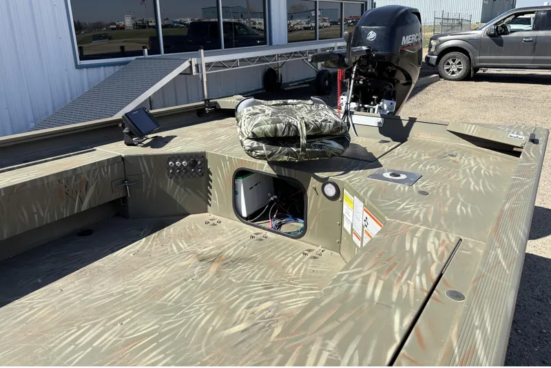 Slide: The Image of 2024 Tracker Grizzly 1654 T Sportsman boat with camouflage seating and Mercury outboard motor. - 4