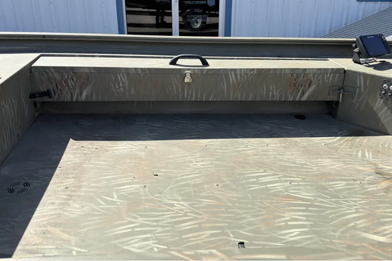 Slide: The Image of 2024 Tracker Grizzly 1654 T Sportsman boat interior with camouflage pattern and storage compartment. - 5