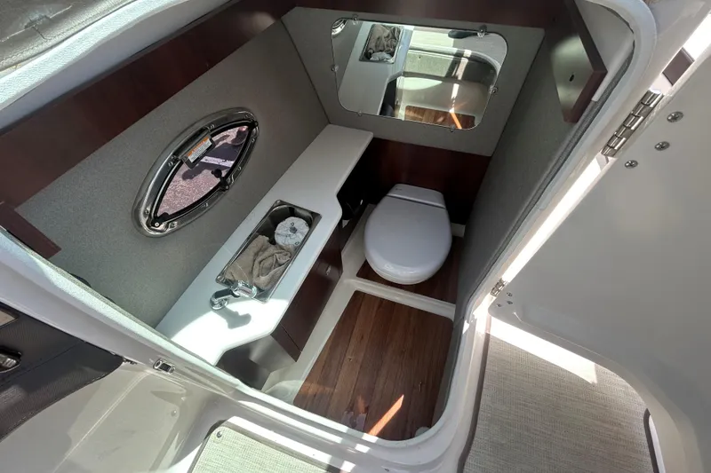 Slide: The Image of 2018 Chaparral 267 SSX boat bathroom interior with sink, toilet, and mirror. - 11