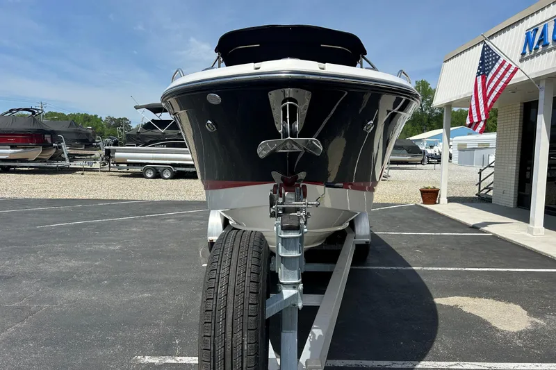 Slide: The Image of 2018 Chaparral 267 SSX boat on trailer, parked at dealership with American flag. - 2