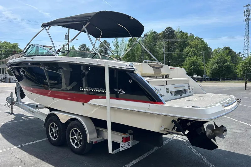 Slide: The Image of 2018 Chaparral 267 SSX boat on trailer, parked outdoors with trees in background. - 4