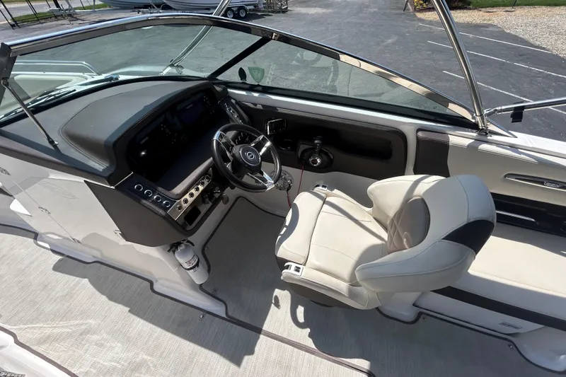 Slide: The Image of 2018 Chaparral 267 SSX boat cockpit with steering wheel and comfortable seating. - 7