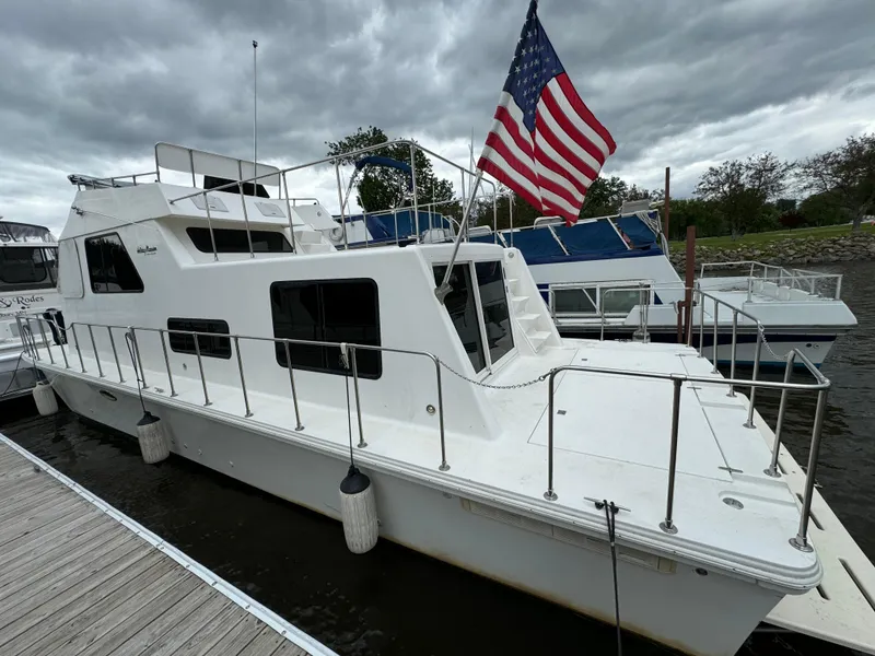 Slide: The Image of Holiday Mansion 37 houseboat, 2008 model, docked with American flag, overcast sky. - 2