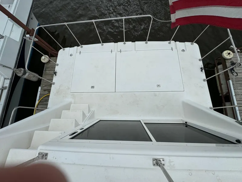 Slide: The Image of Holiday Mansion 37 boat deck, 2008 model, with stairs and railing, docked by water. - 3