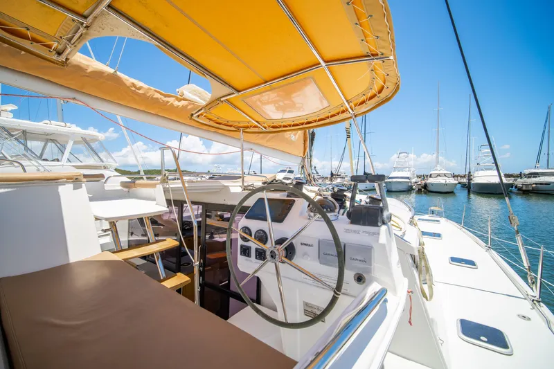 Slide: The Image of 2014 Fountaine Pajot Helia 44 catamaran cockpit with yellow canopy, docked in marina. - 11