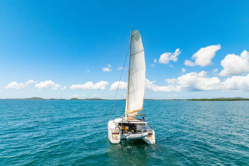 Slide: The Image of 2014 Fountaine Pajot Helia 44 catamaran sailing on open sea under clear blue sky. - 53