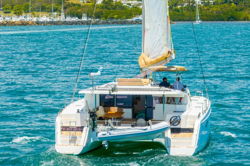 Slide: The Image of 2014 Fountaine Pajot Helia 44 catamaran sailing on blue waters near a marina. - 57