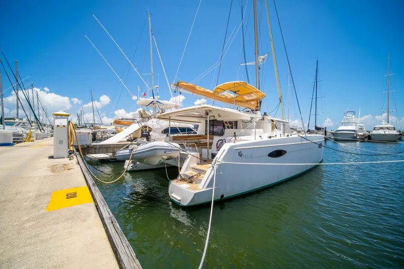 Slide: The Image of 2014 Fountaine Pajot Helia 44 catamaran docked at marina under clear blue sky. - 7