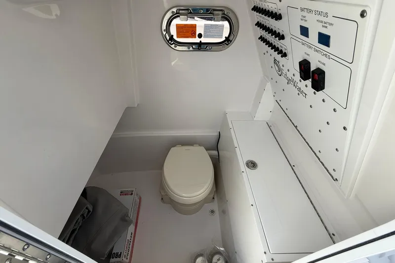 Slide: The Image of Interior of 2026 Edgewater 250CC boat featuring a compact marine toilet and control panel. - 18