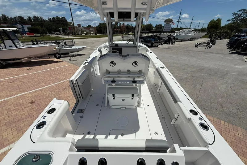 Slide: The Image of 2026 Edgewater 250CC boat interior, showcasing spacious deck and seating area at a marina. - 6