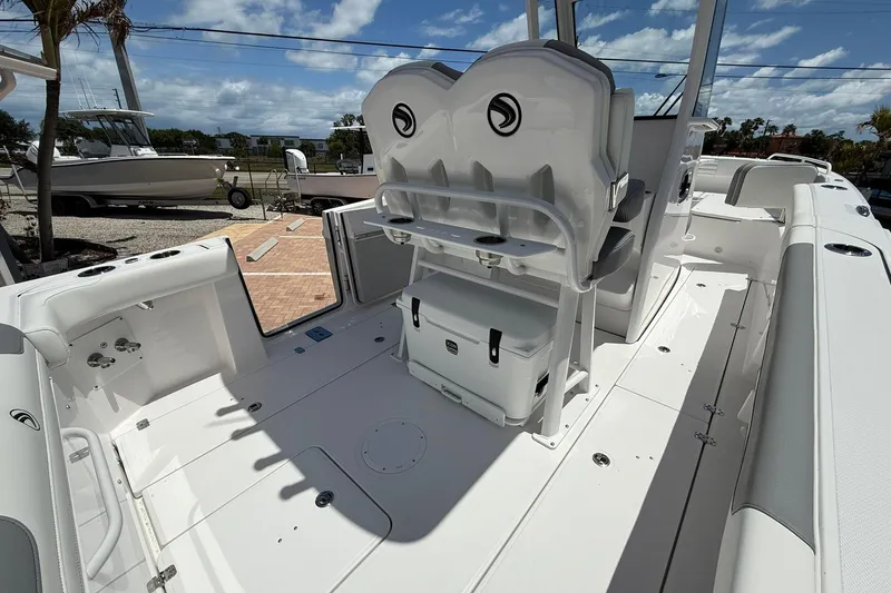 Slide: The Image of 2026 Edgewater 250CC boat interior with seating and storage, under a sunny sky. - 7