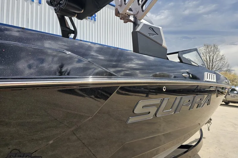 Slide: The Image of 2022 Supra SE 550 boat with sleek black exterior and chrome accents. - 10