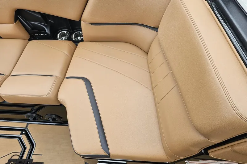 Slide: The Image of Tan leather interior of 2022 Supra SE 550 boat, featuring sleek design and cup holders. - 100