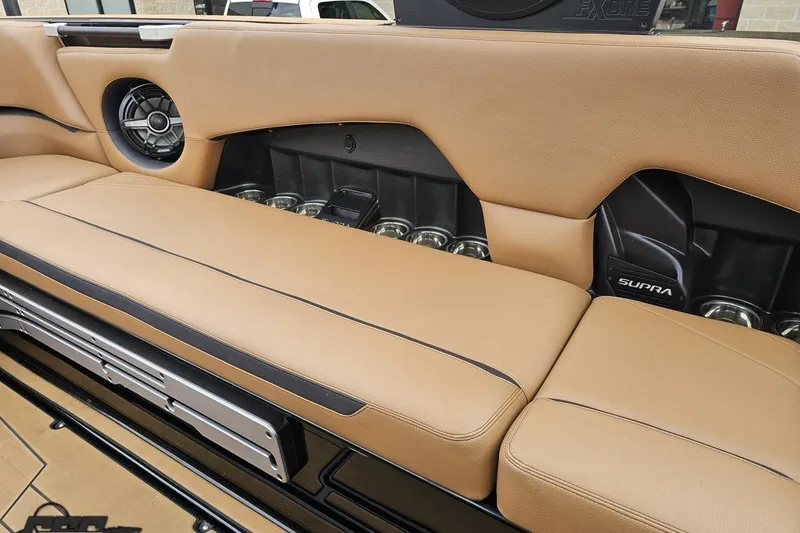 Slide: The Image of 2022 Supra SE 550 boat interior with tan leather seats and built-in speakers. - 101