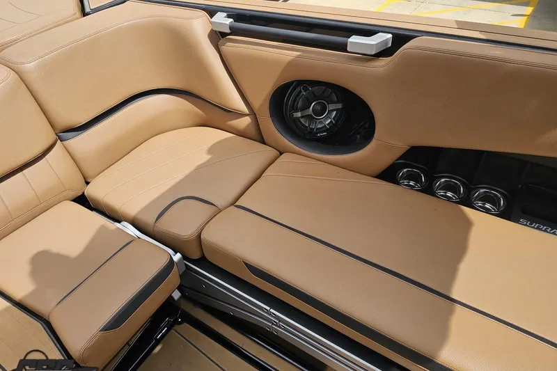 Slide: The Image of 2022 Supra SE 550 boat interior with tan leather seats and built-in speaker system. - 102