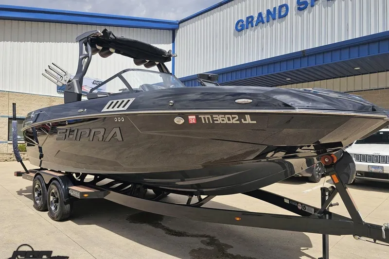 Slide: The Image of 2022 Supra SE 550 boat on trailer at dealership, showcasing sleek design and modern features. - 15
