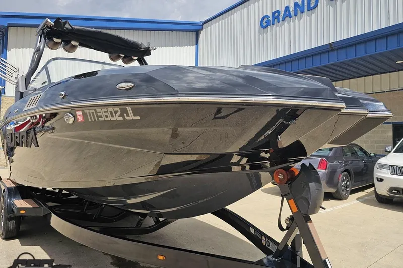 Slide: The Image of 2022 Supra SE 550 boat on trailer outside dealership, showcasing sleek design. - 16