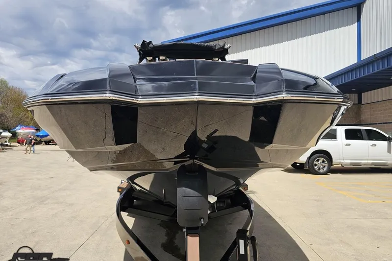 Slide: The Image of 2022 Supra SE 550 boat on trailer, parked outdoors near industrial building. - 17