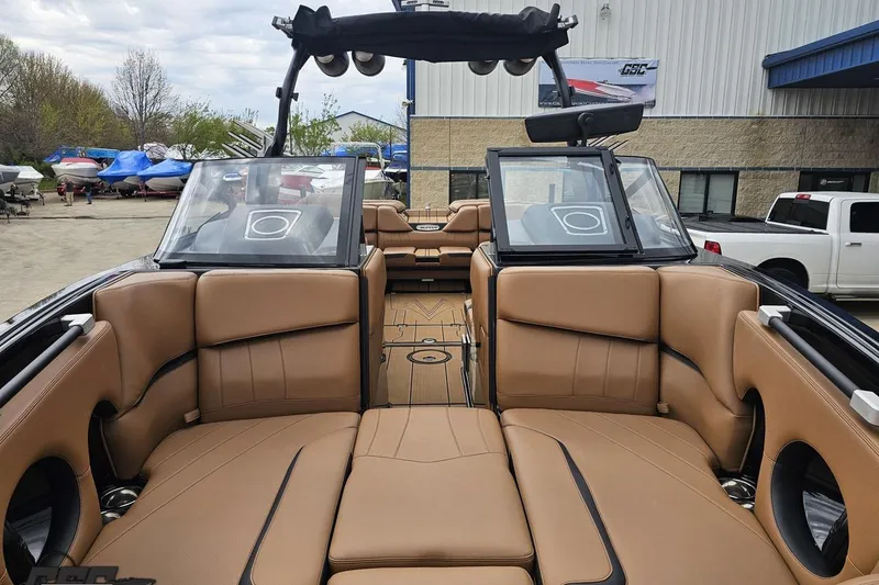 Slide: The Image of 2022 Supra SE 550 boat interior with tan leather seating and open windshield. - 19