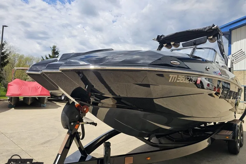 Slide: The Image of 2022 Supra SE 550 boat on trailer, parked outdoors under cloudy sky. - 20