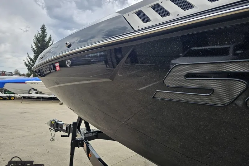 Slide: The Image of 2022 Supra SE 550 boat on trailer, sleek black design, outdoor setting. - 26