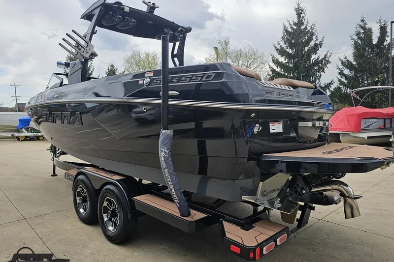 Slide: The Image of 2022 Supra SE 550 boat on trailer, sleek black design, outdoor setting. - 29