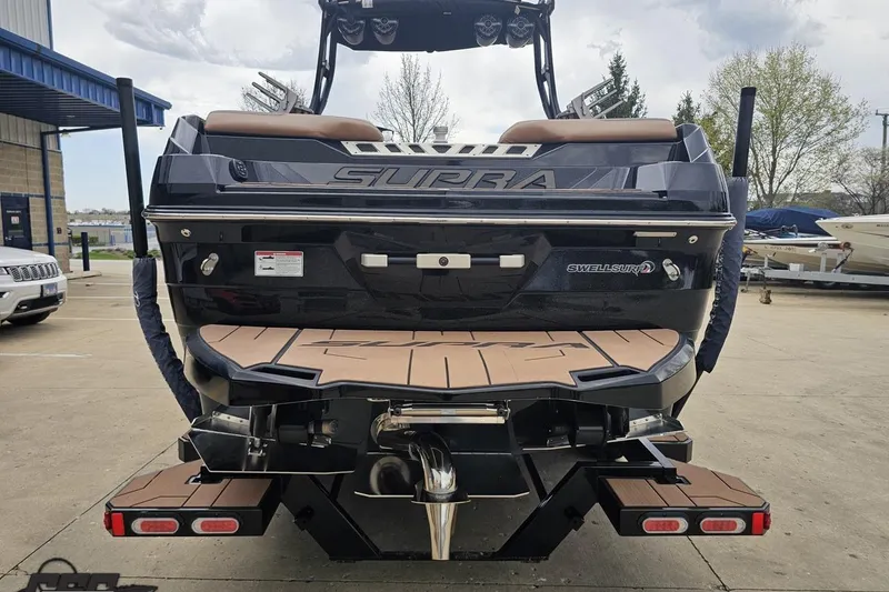 Slide: The Image of 2022 Supra SE 550 boat rear view with Swell Surf system in a marina. - 31