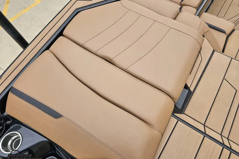 Slide: The Image of 2022 Supra SE 550 boat interior with tan leather seating and cup holders. - 45